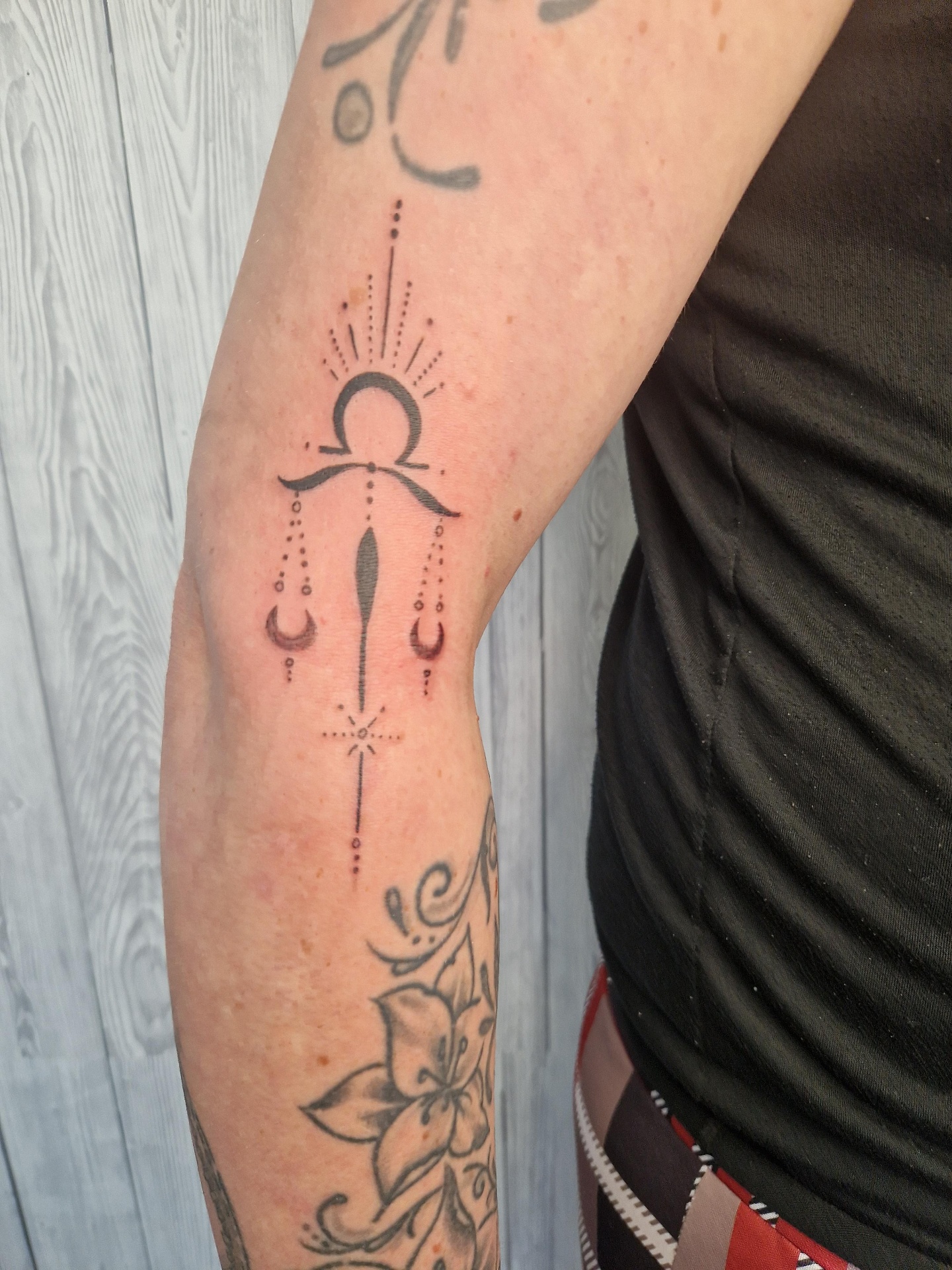 Ornamentales Sonnen-Tattoo am Ellbogen