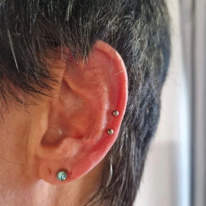 Frisch gestochenes Helix-Piercing mit Titan-Schmuck
